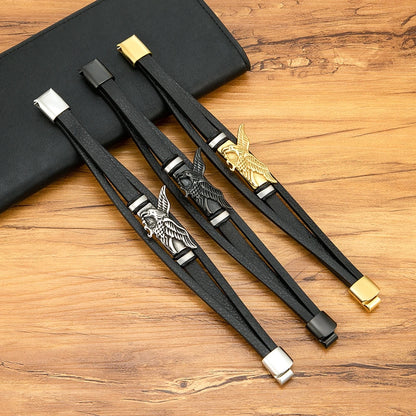 Black leather straps with metal eagle buckles on a wooden surface
