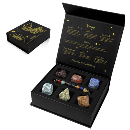 Black box with astrological theme containing various stones, open on a white background