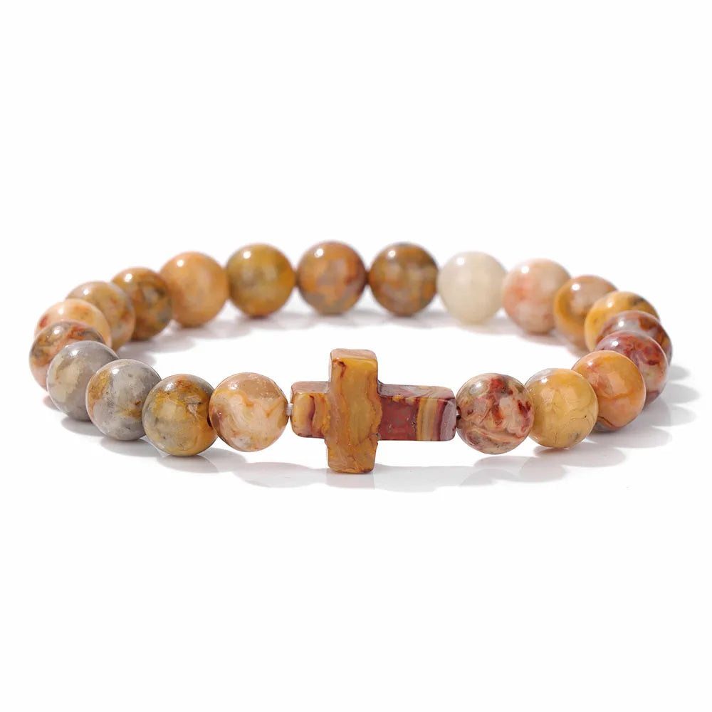 Beaded bracelet with a cross charm on a white background
