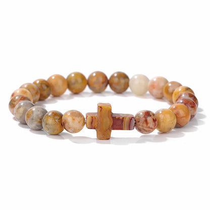 Beaded bracelet with a cross charm on a white background