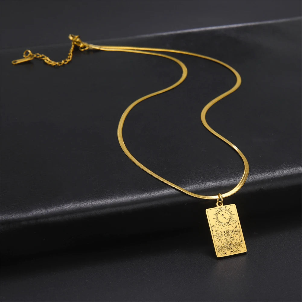 Gold necklace with a rectangular pendant on a black background