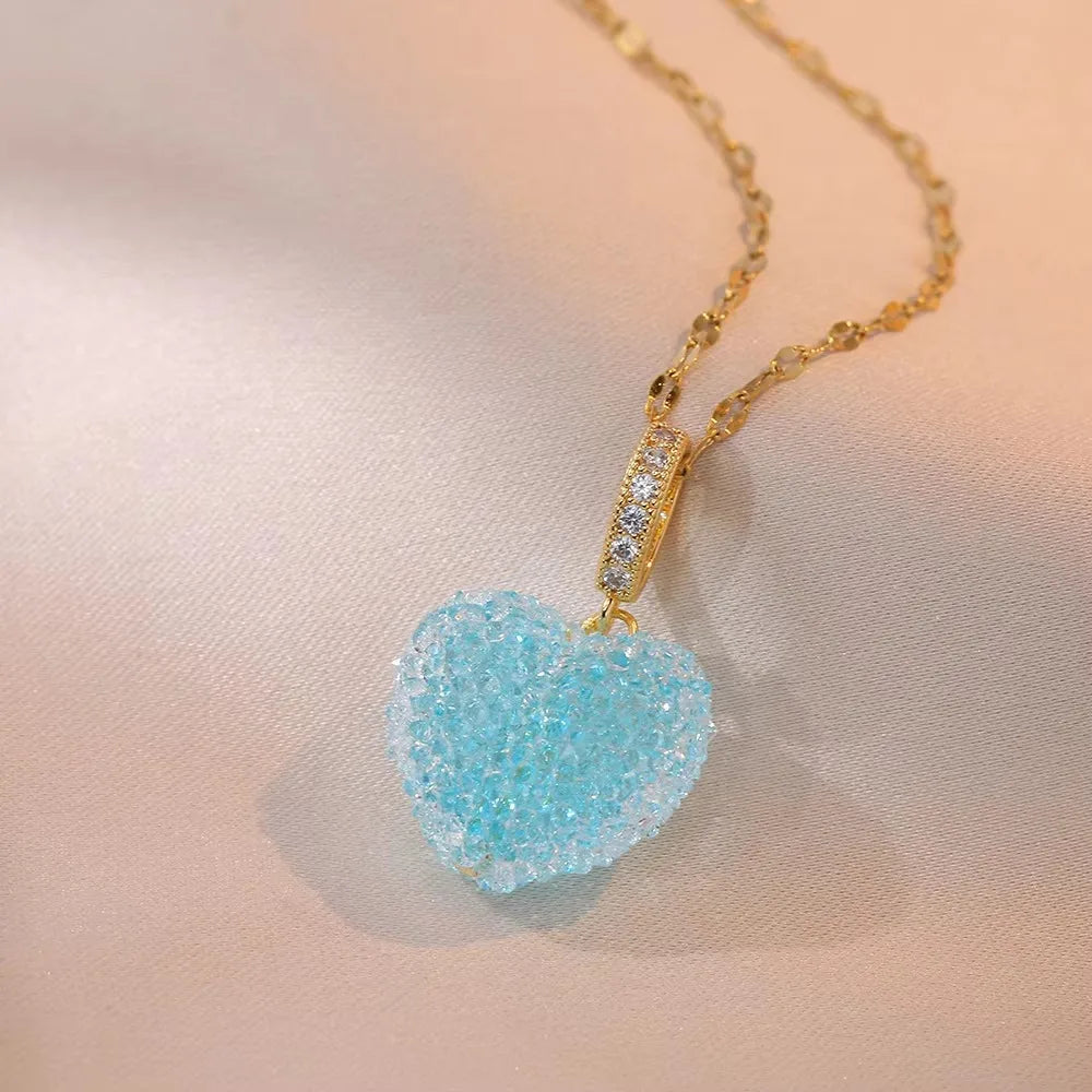 Necklace with a blue heart-shaped pendant on a soft pink background