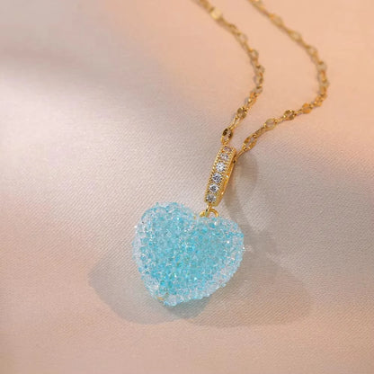 Necklace with a blue heart-shaped pendant on a soft pink background
