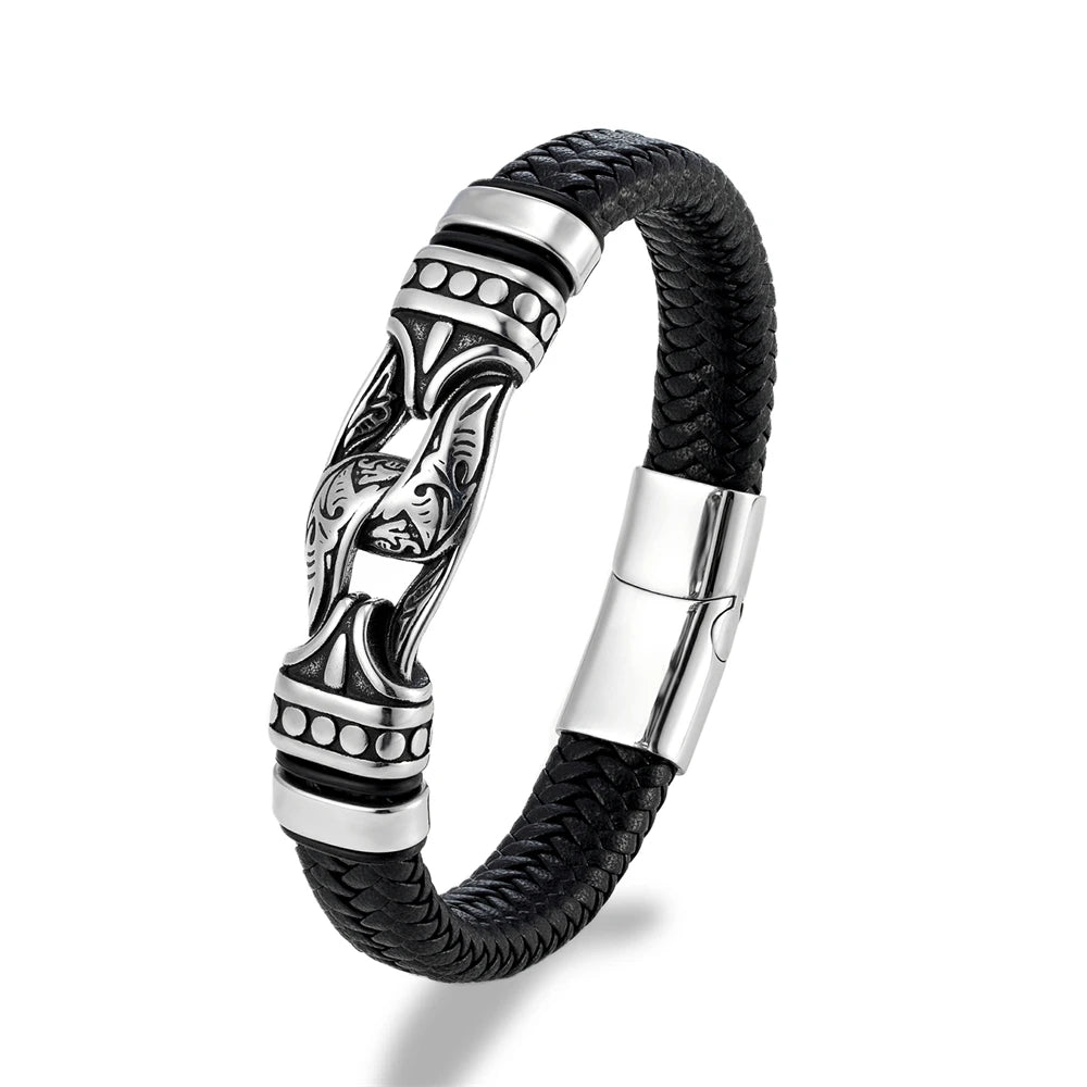 A men's black braided leather bracelet with a polished silver-toned metal centerpiece featuring a stylized face motif and geometric accents, shown on a white background.