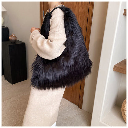 Person holding a black fur bag indoors