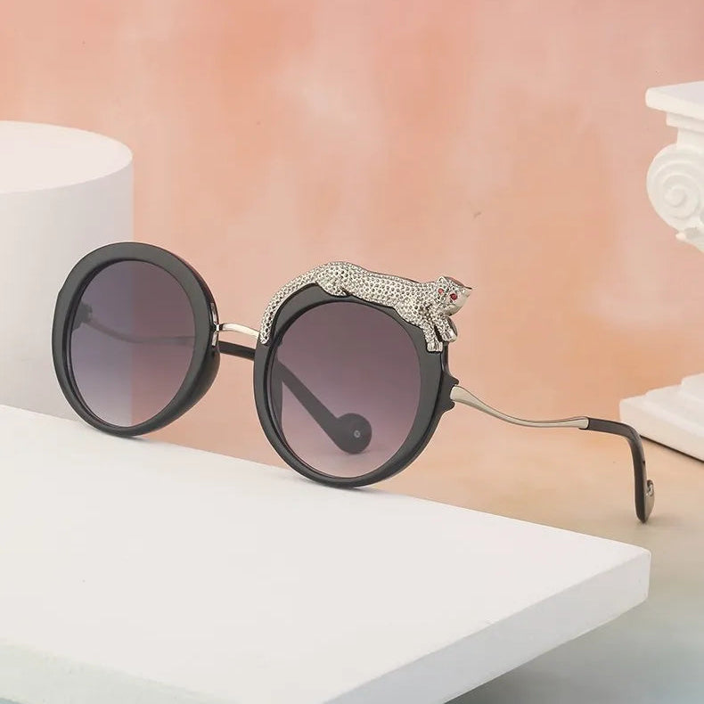 Sunglasses with decorative arm on a white surface with a blurred background