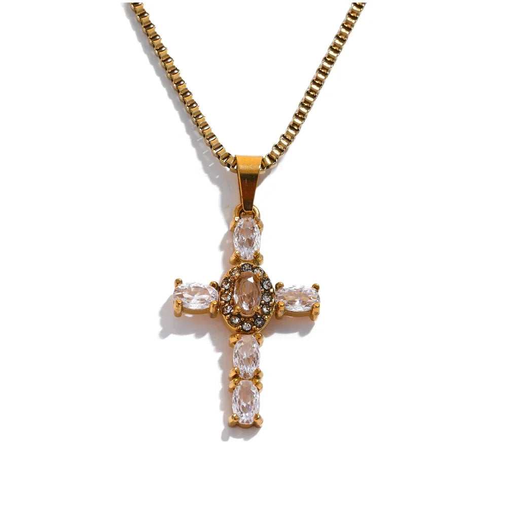 Gold cross pendant necklace with clear stones on a white background