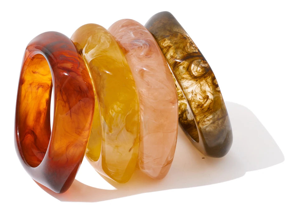 Four amber-coloured bangles on a white background