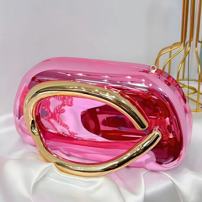 Pink handbag with gold accents on a white surface