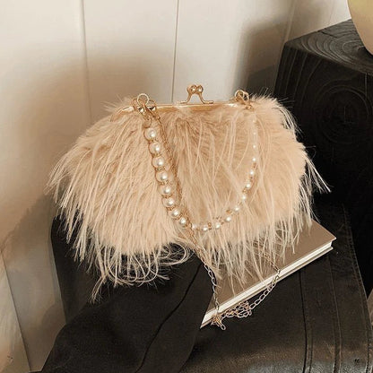Feathered handbag with pearl details on a black surface