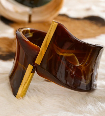 Brown bracelet with gold accents on a fur surface