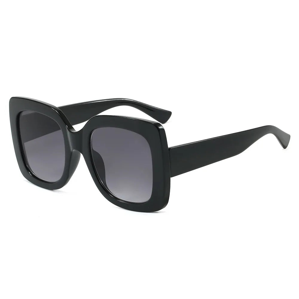 Black oversized square sunglasses with gradient grey lenses, shown at a three-quarter angle on a plain white background.