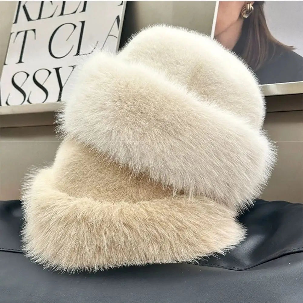 Two fluffy hats in white and beige colour on a dark surface with a blurred background