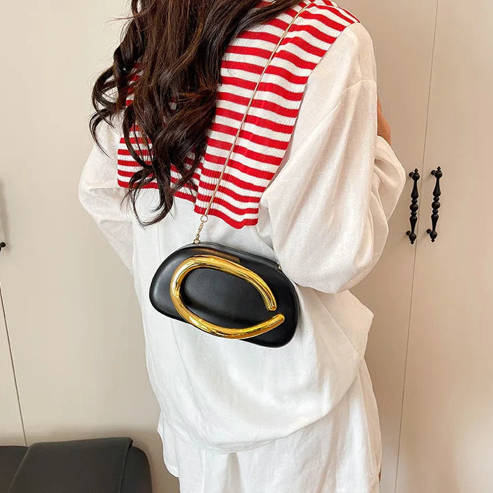 Person wearing a red and white striped top with a black and gold handbag.