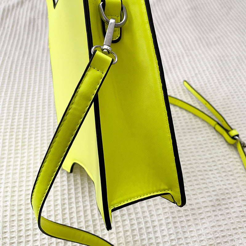 Yellow handbag with a strap on a textured white background
