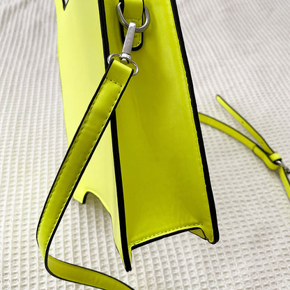Yellow handbag with a strap on a textured white background