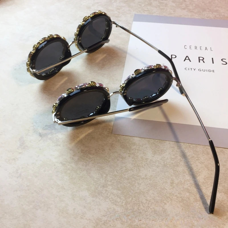 Decorative sunglasses with gemstones on a textured surface