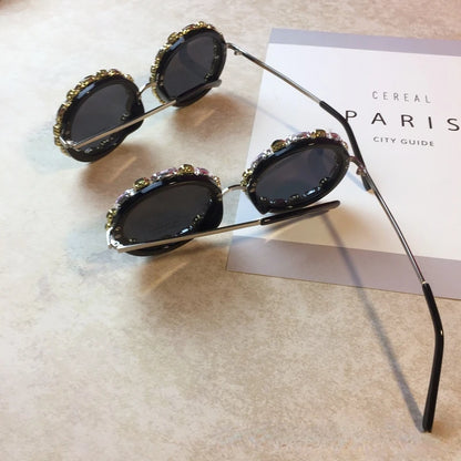 Decorative sunglasses with gemstones on a textured surface
