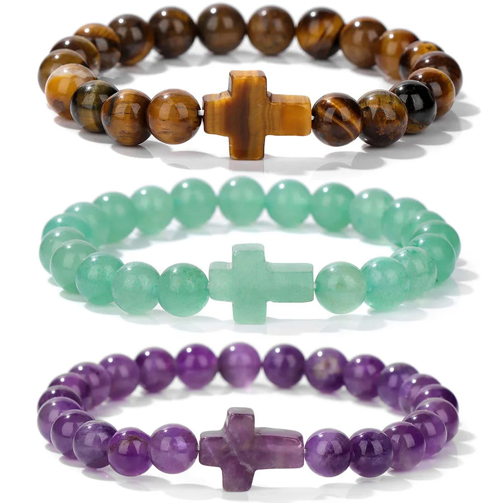 Three beaded bracelets with cross charms on a white background