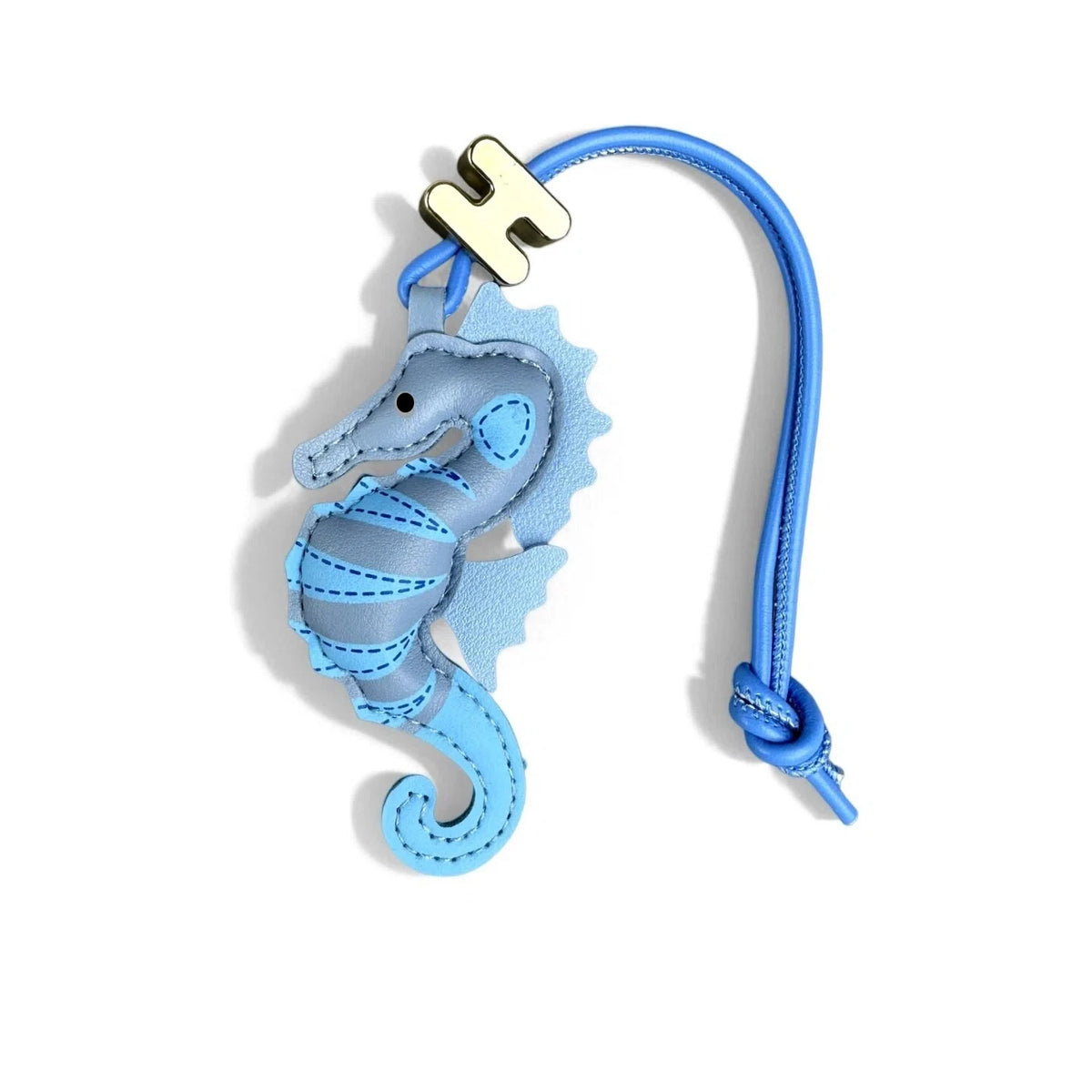 A light blue leather seahorse charm with a blue strap and a gold-tone H logo, shown on a clean white background.