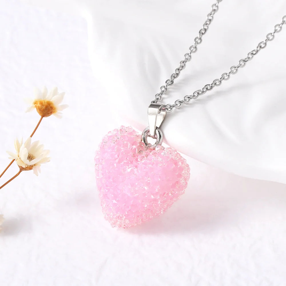 Pink heart-shaped pendant on a chain with a white background