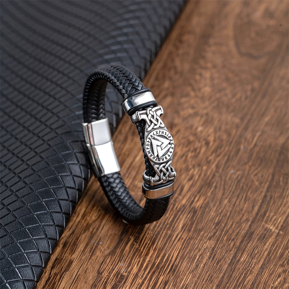 Black braided leather bracelet with silver clasp on a wooden surface