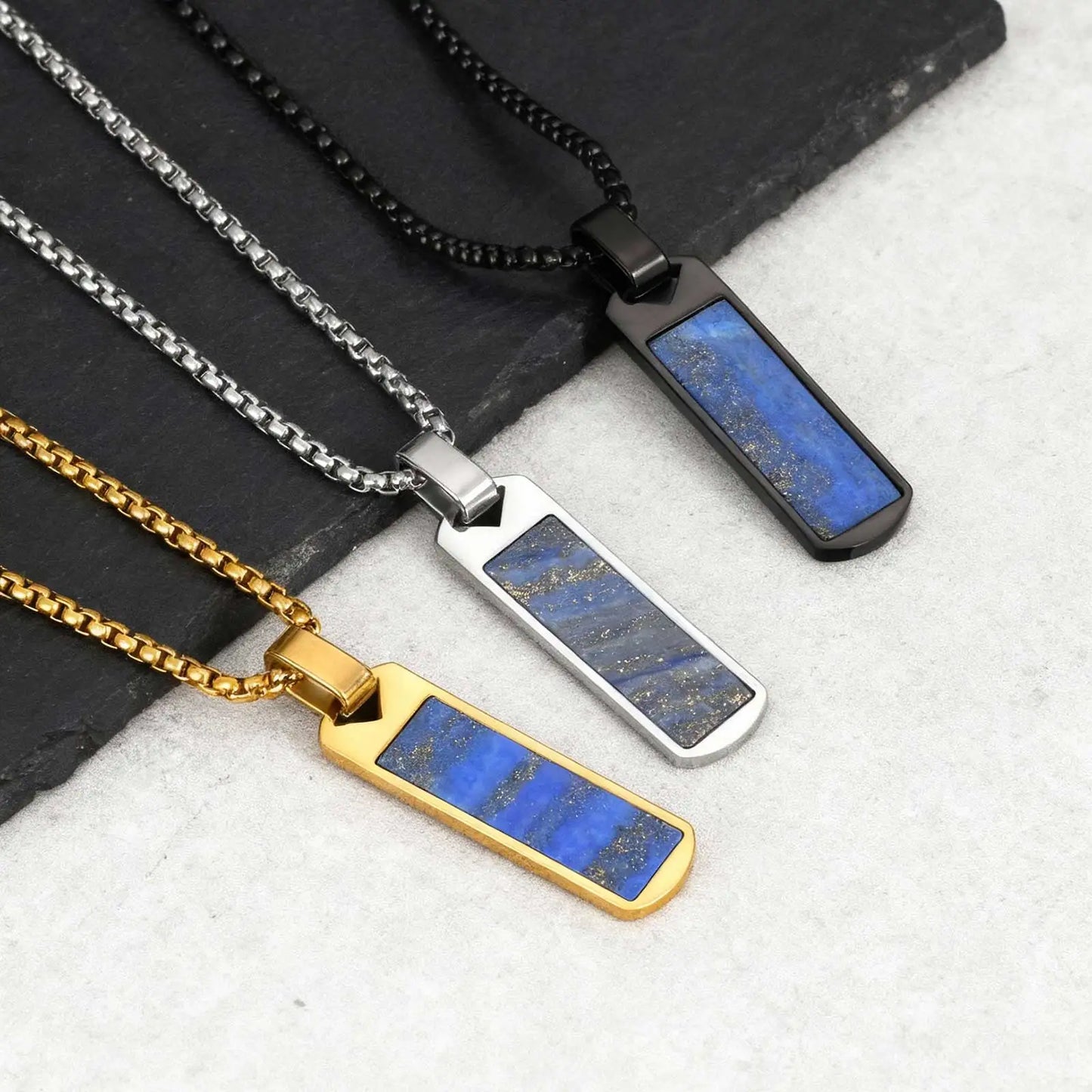 Three necklaces with blue stone pendants on black and white background