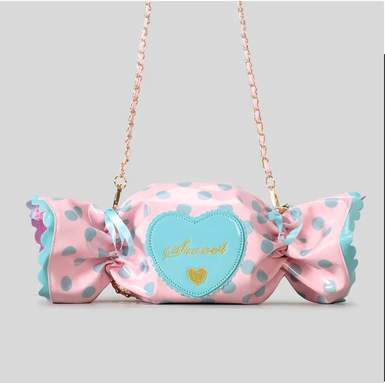 Pink polka dot bag with a large bow and heart-shaped patch on a grey background