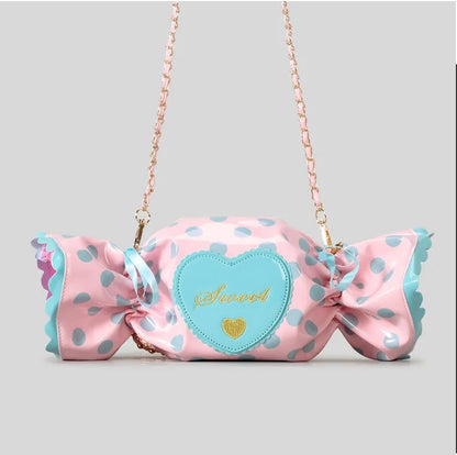 Pink polka dot bag with a large bow and heart-shaped patch on a grey background