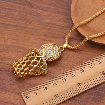 Gold basketball hoop necklace on a wooden surface with a ruler for scale.