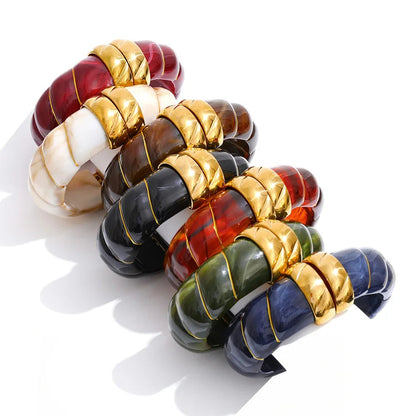 Set of colourful beaded bracelets with gold accents on a white background.