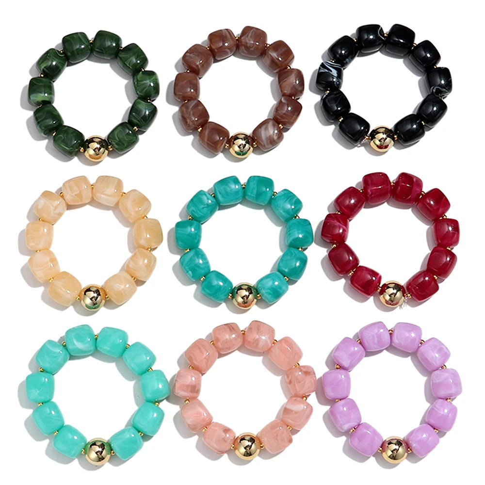 Set of colourful beaded bracelets with gold accents on a white background