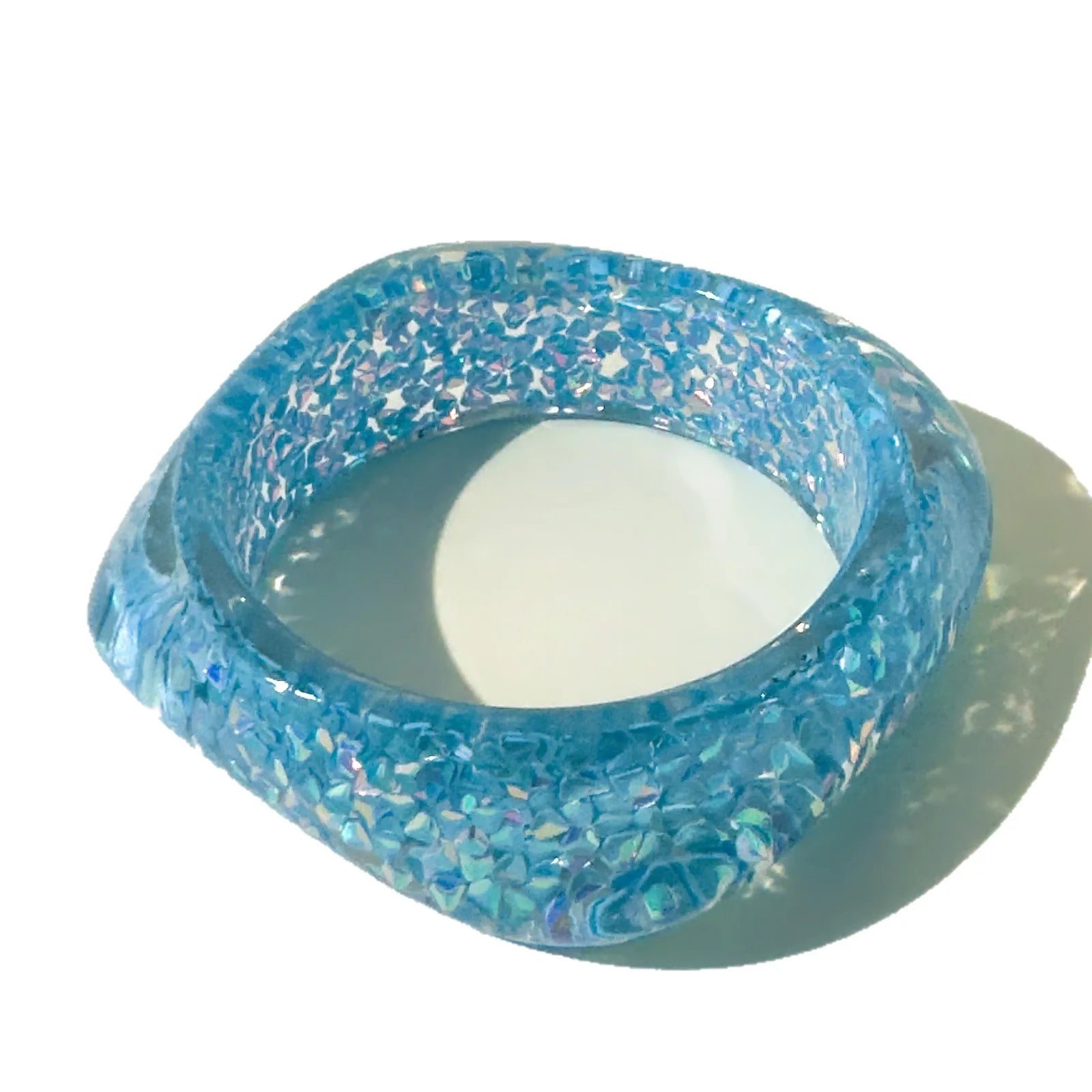 Blue glittery bangle on a white background