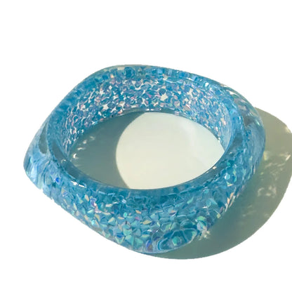 Blue glittery bangle on a white background