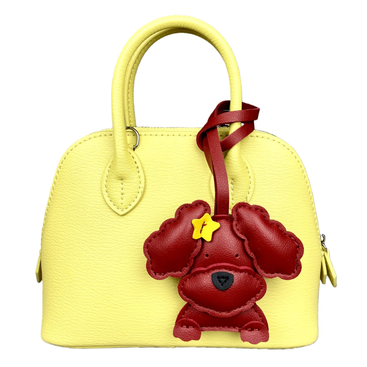 Yellow handbag with a red dog charm on a white background