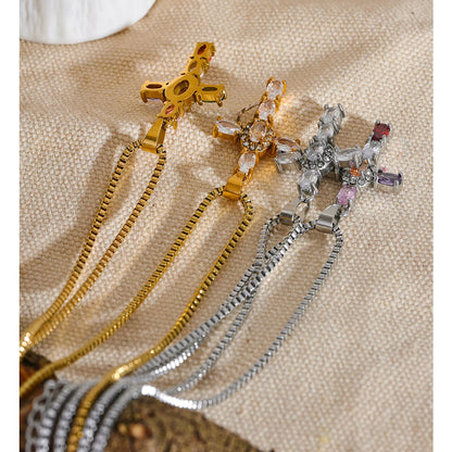 Four necklaces with cross pendants in gold and silver, on a textured surface