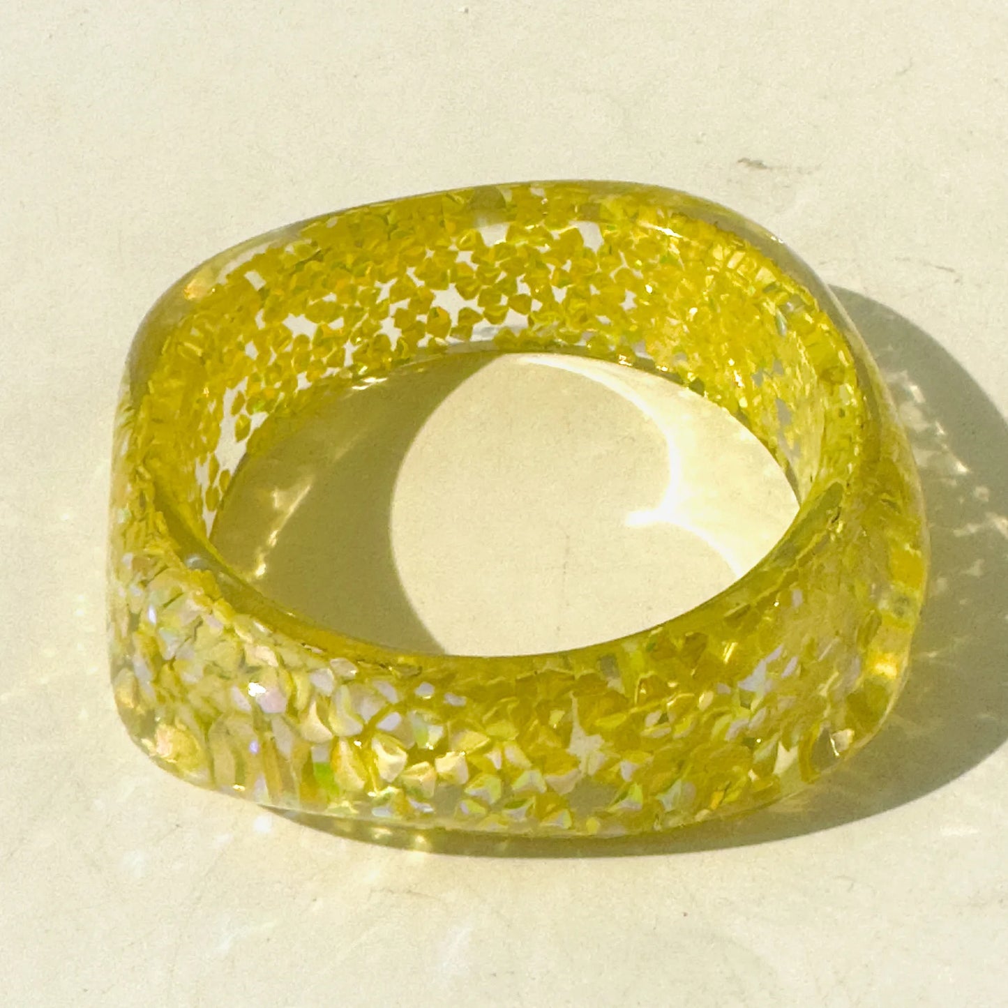 Yellow bracelet with speckled pattern on a light background