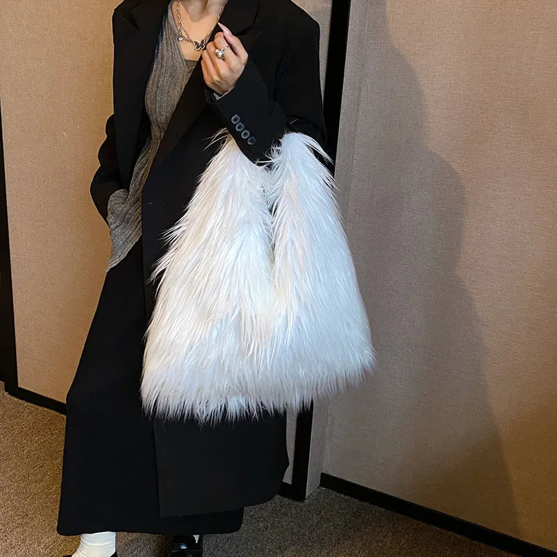 Person holding a white feathered bag against a plain background