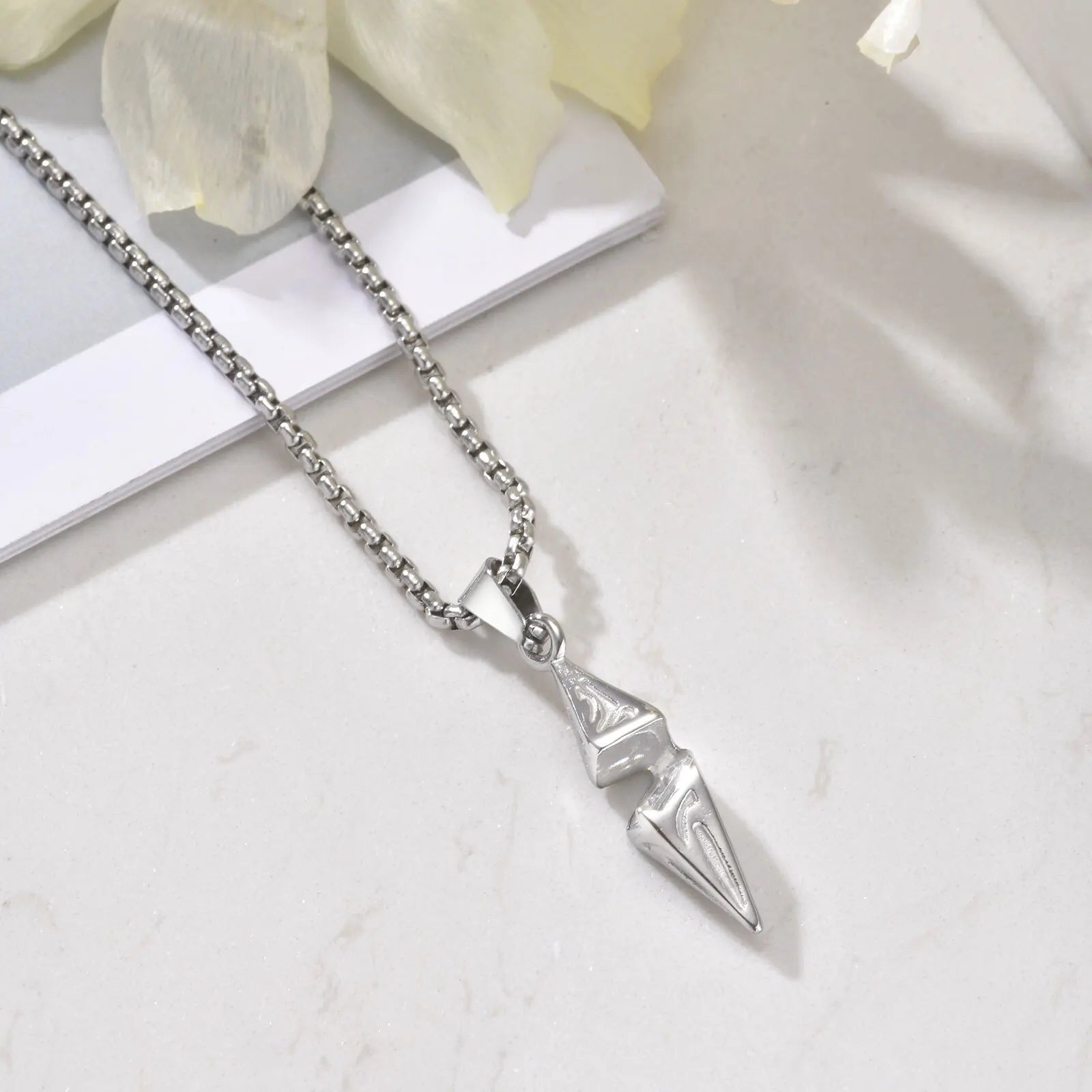Silver necklace with a unique pendant on a light background