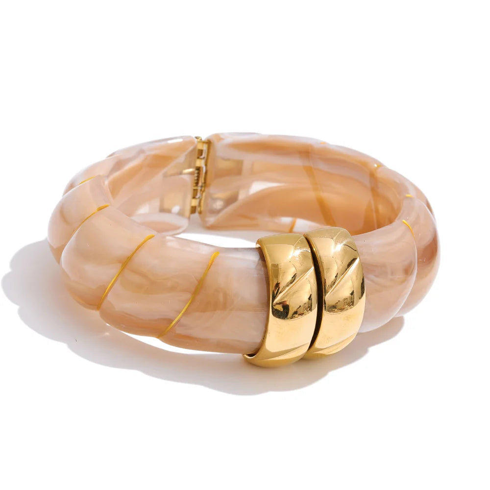 Beige bangle with gold accents on a white background