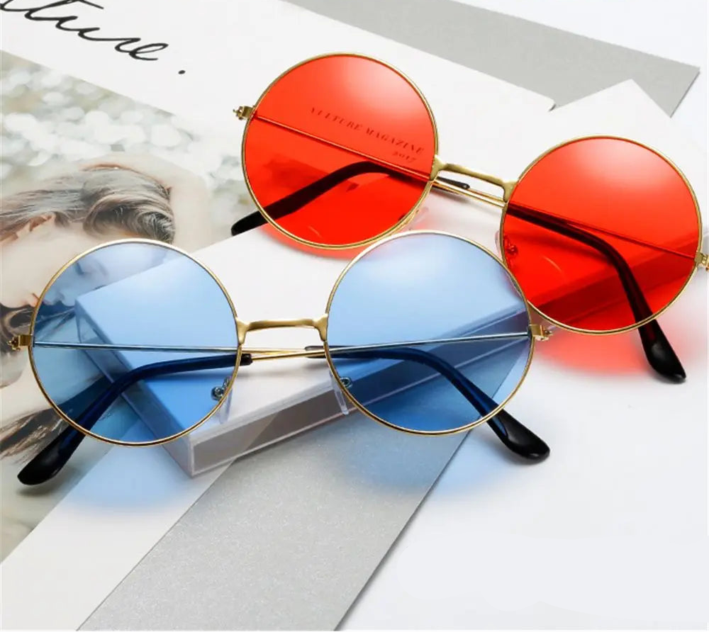 Two pairs of sunglasses with red and blue lenses on a magazine background.