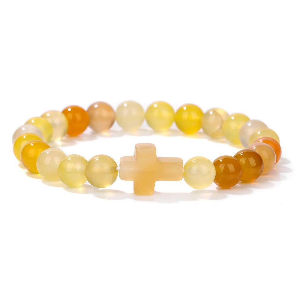Multicoloured beaded bracelet with a cross charm on a white background