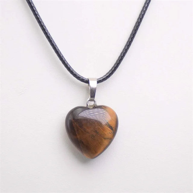 Heart-shaped pendant on a black cord against a white background
