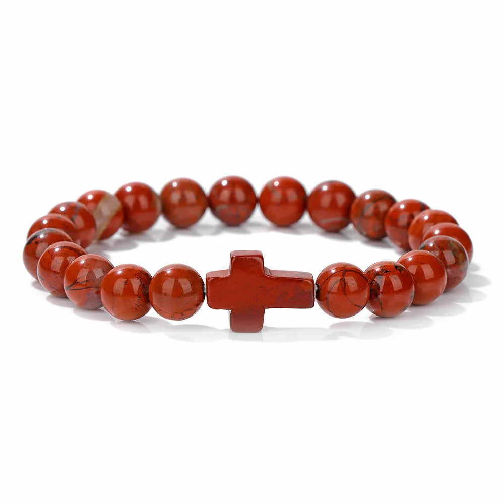Red beaded bracelet with a cross charm on a white background