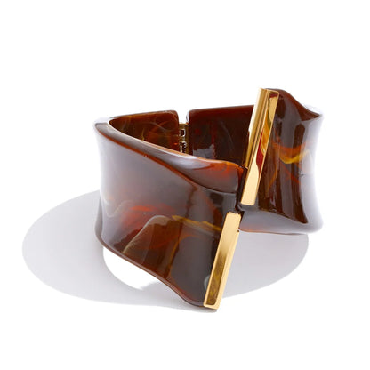 Brown tortoiseshell and gold bracelet on a white background