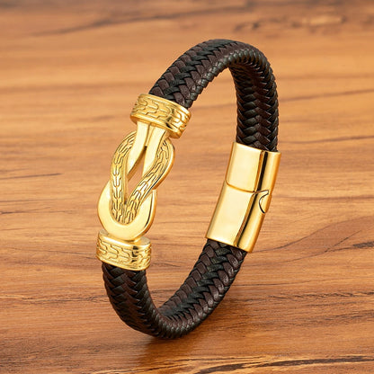 Bracelet with gold clasp and black braided strap on wooden surface