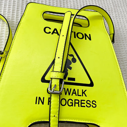 Neon yellow bag with a warning sign design on a textured background