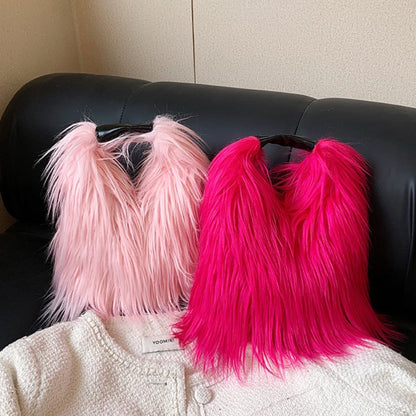 Pink and red fluffy bags on a black leather couch.