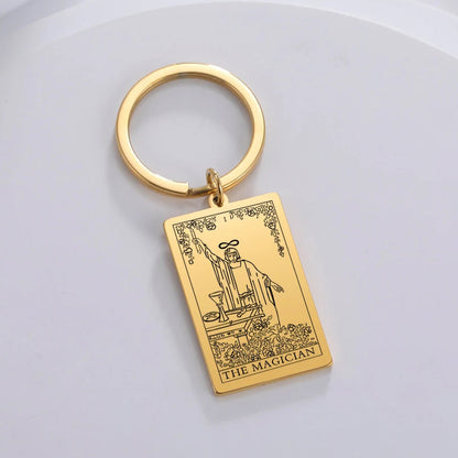 Gold keychain with 'The Magician' tarot card design on a light grey background