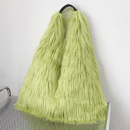 Light green tote bag on a trolley against a white wall